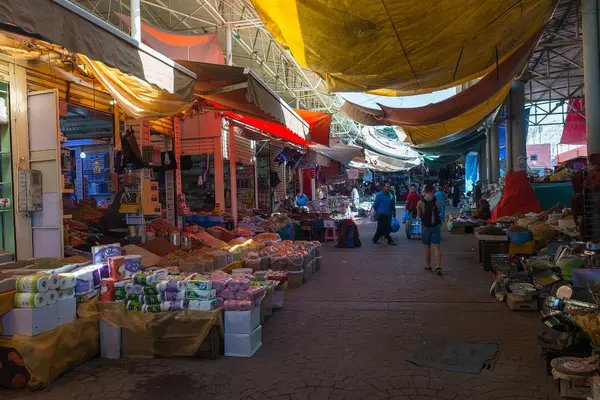 A covered aisle of dried fruit, spice and household stalls in a Moroccan souk